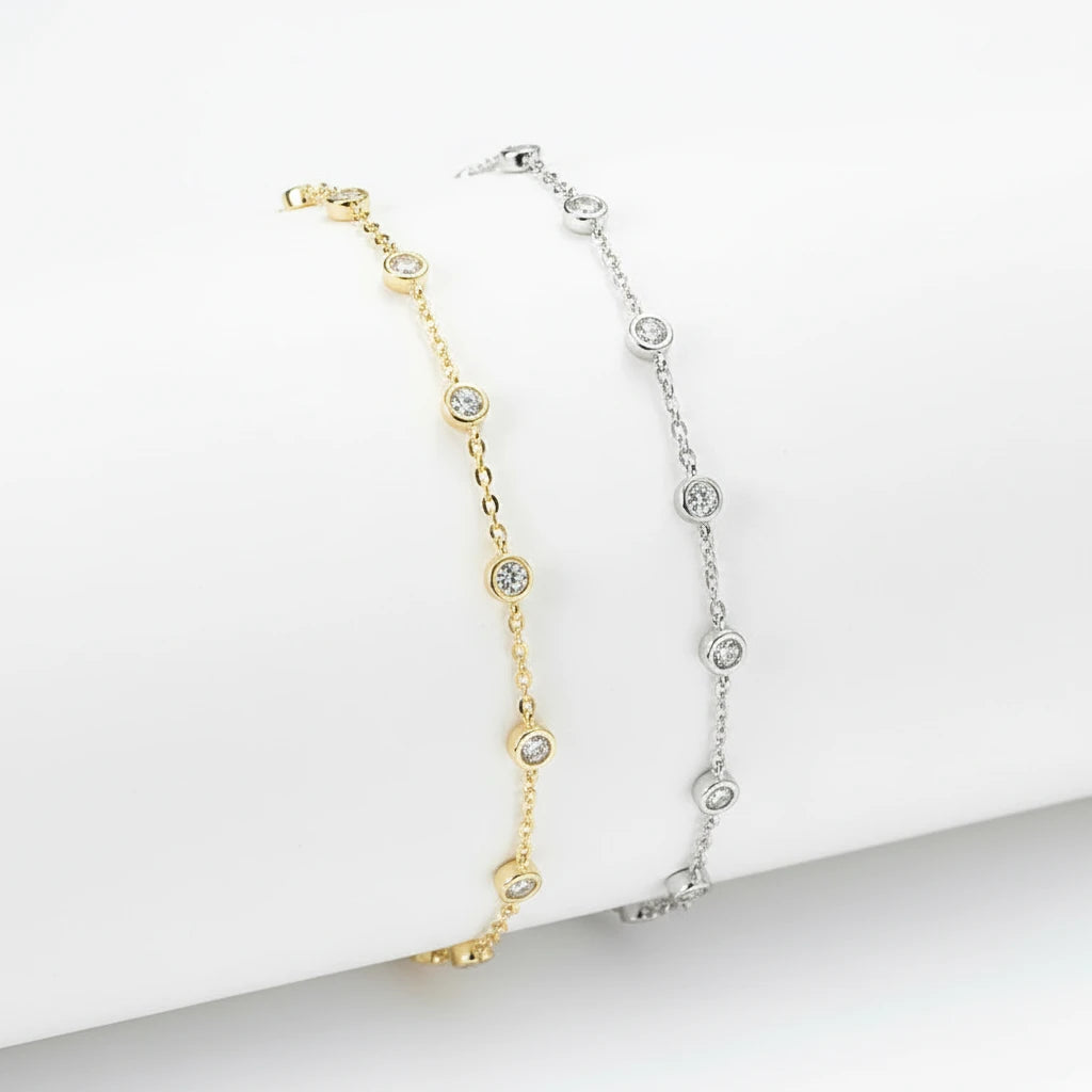 Two gold and silver beaded necklaces on a white stone surface.