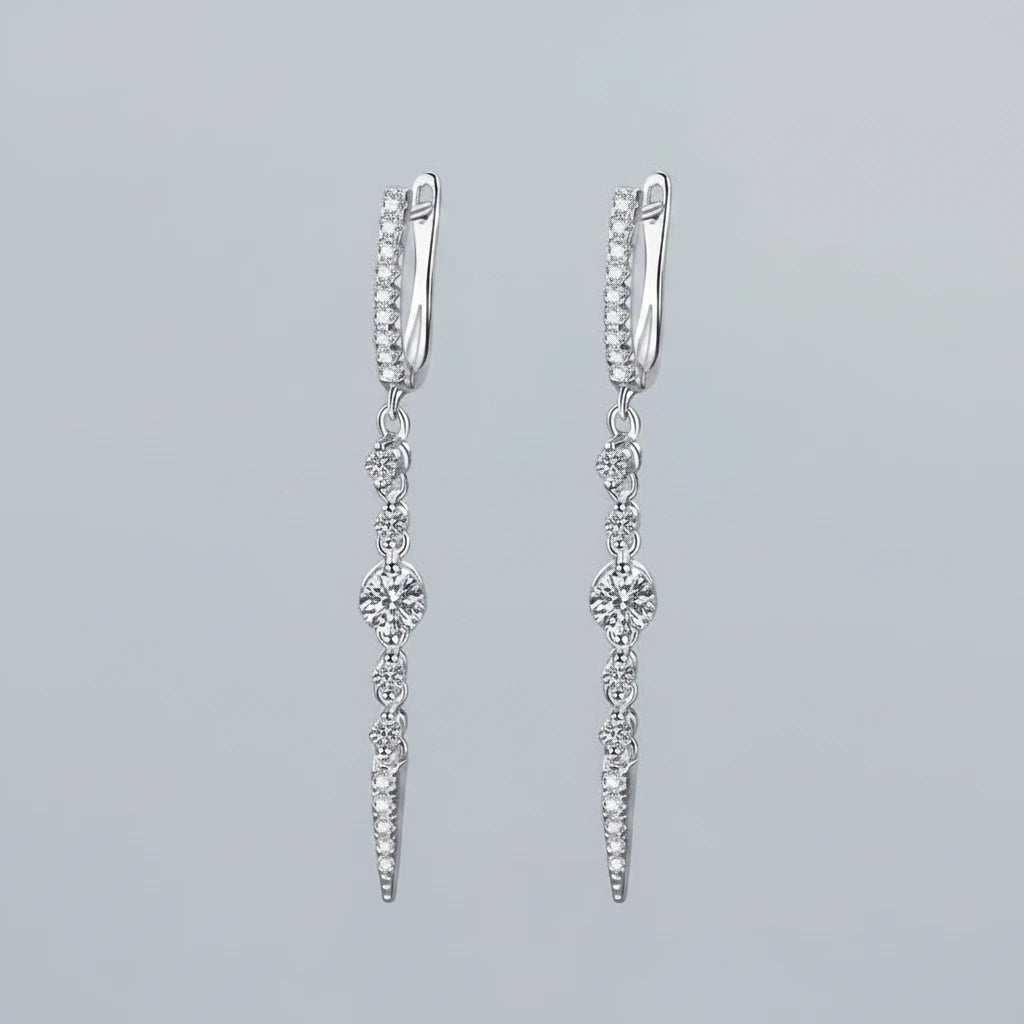 Silver earrings with gemstones on a teal background