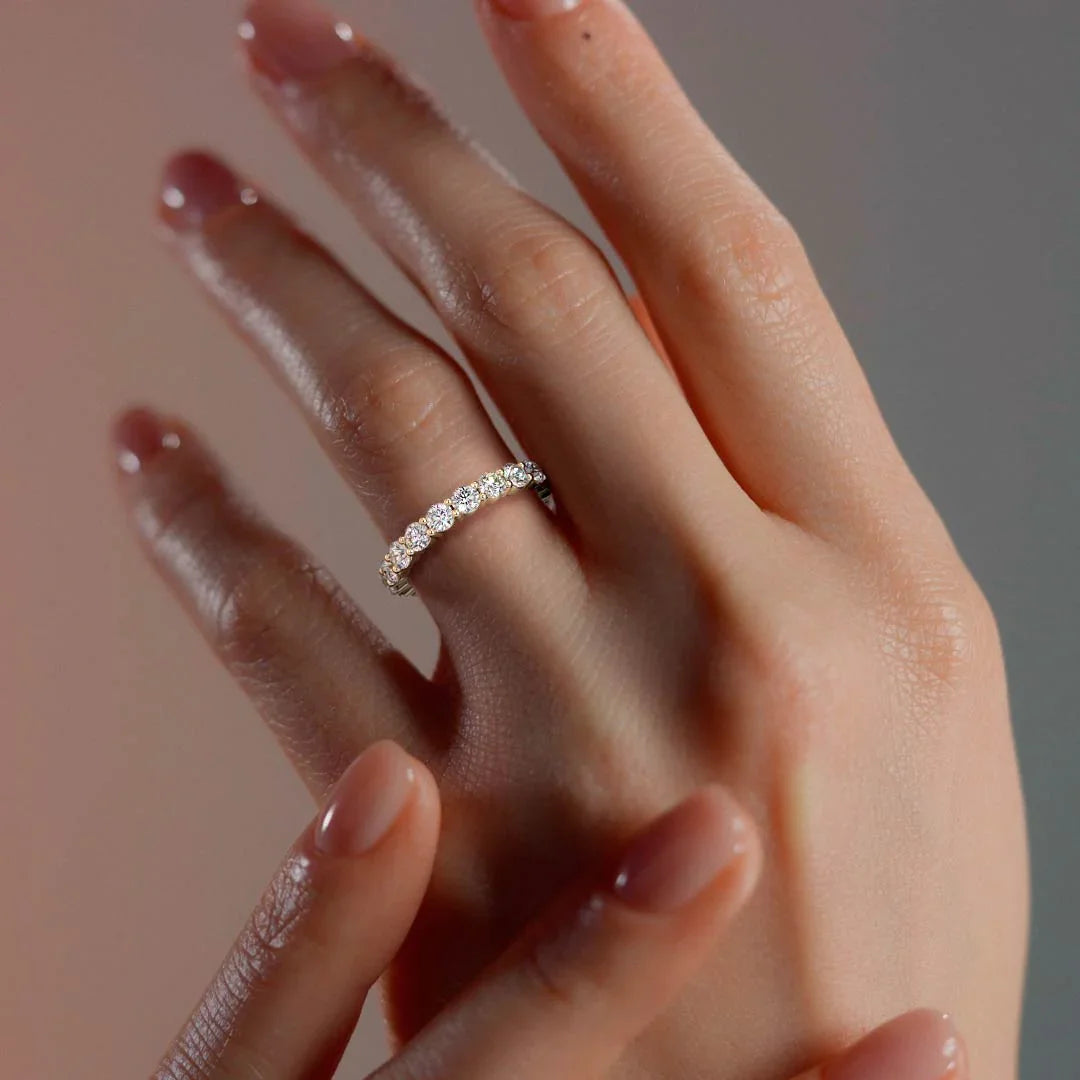 Hand wearing a diamond ring with a soft background