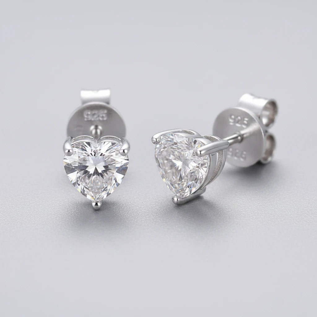 Pair of silver heart-shaped stud earrings on a dark surface