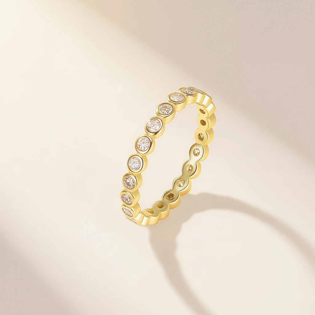 Gold ring with embedded diamonds on a beige background