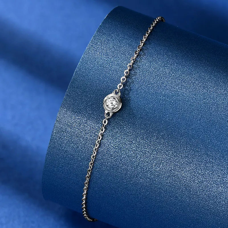 Silver bracelet with a chain on a blue textured background