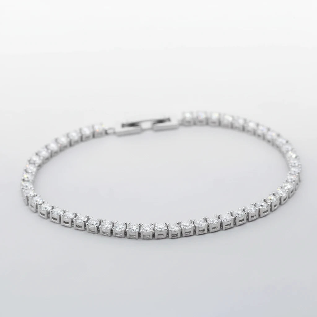 Silver bracelet with clear stones on a light blue background