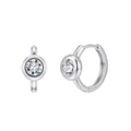 A pair of silver hoop earrings with a single round clear gemstone in a bezel setting, shown from two angles on a plain white background.