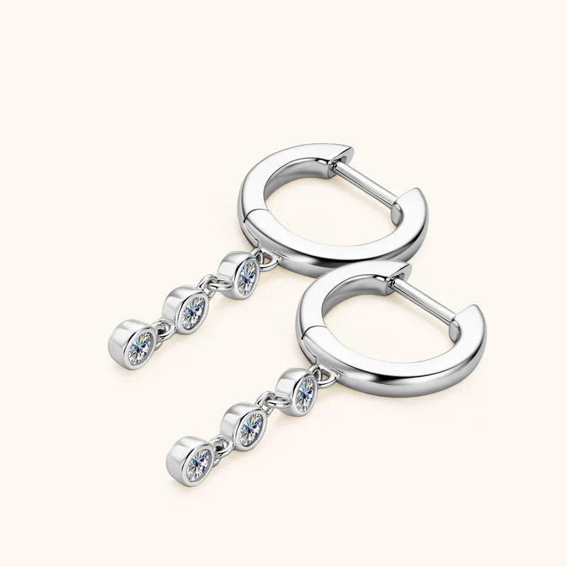 Silver hoop earrings with dangling gemstones on a white background