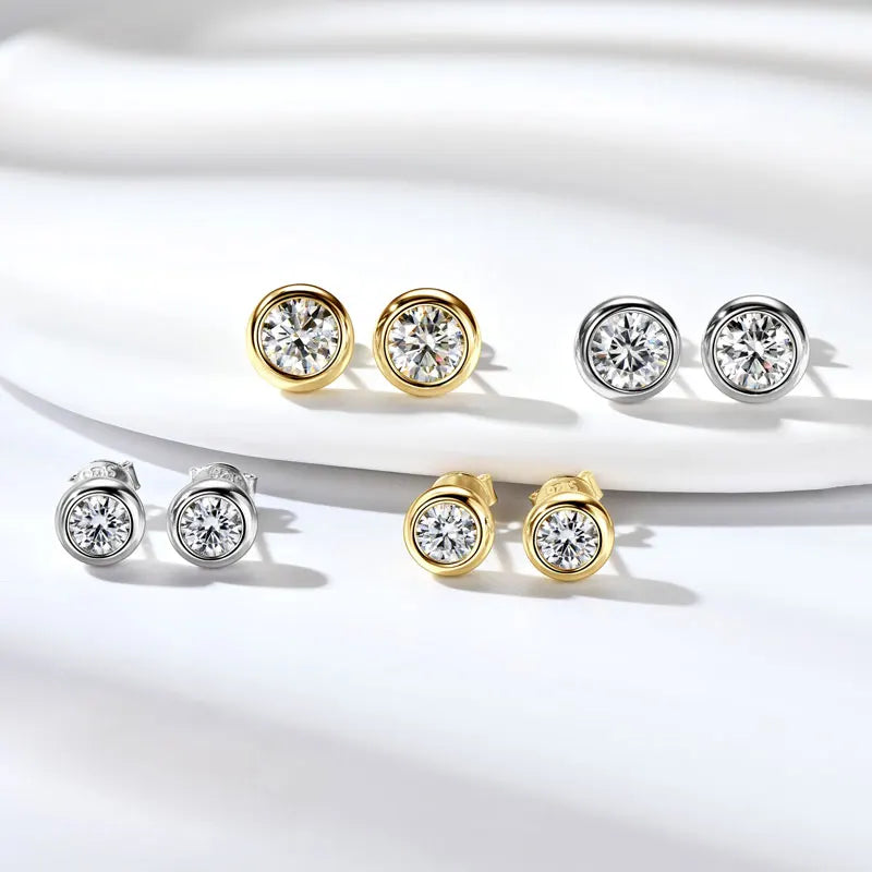 Pair of diamond stud earrings in gold and silver on a white background
