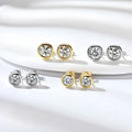 Pair of diamond stud earrings in gold and silver on a white background