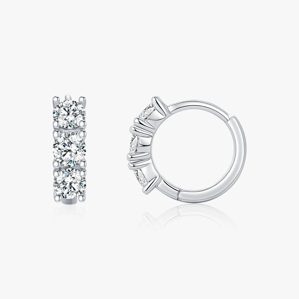 Pair of silver hoop earrings with clear gemstones on a white background