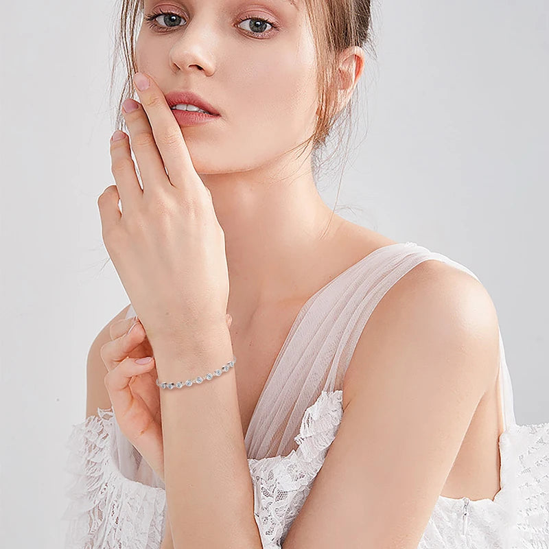 Woman wearing a delicate bracelet on a plain background