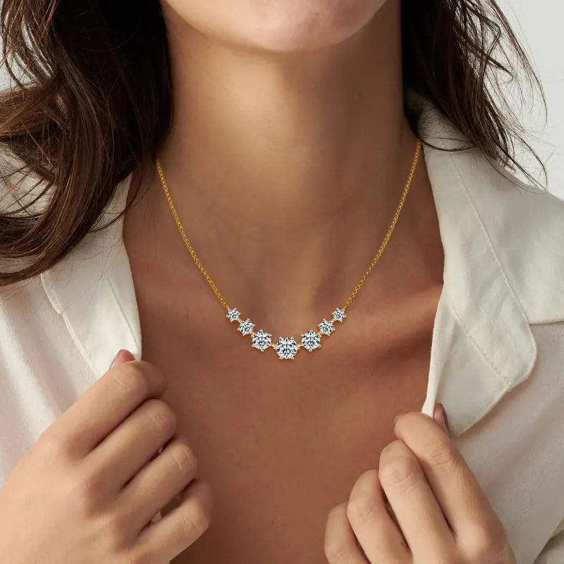 Gold necklace with star-shaped gemstones worn by a person