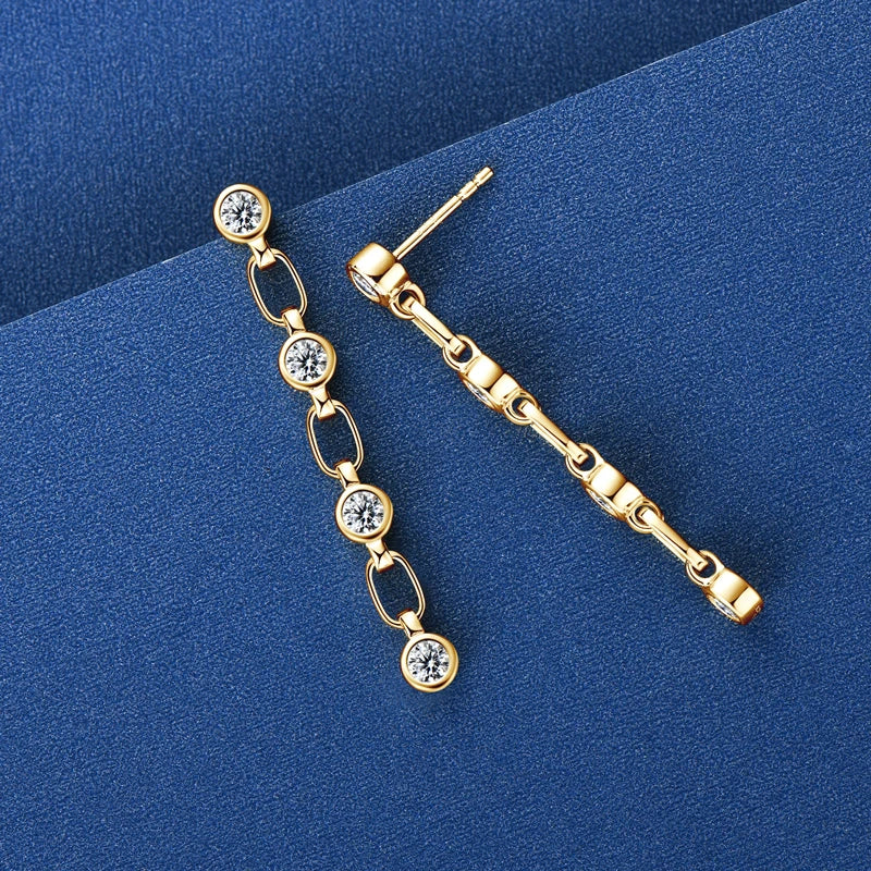 Gold earrings with clear stones on a blue background