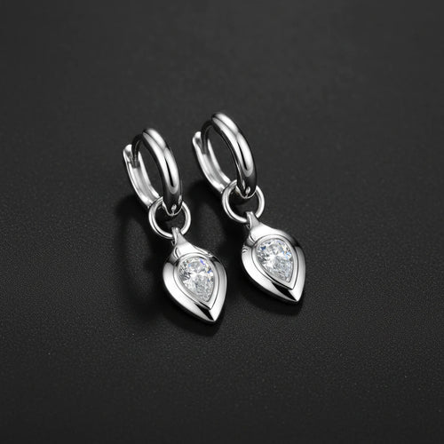 Silver earrings with heart-shaped gemstones on a light blue background