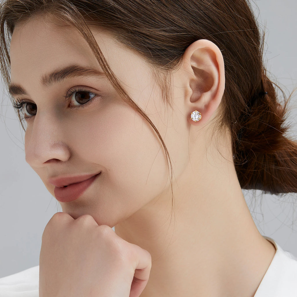 Close-up of a woman wearing a diamond earring with a neutral background