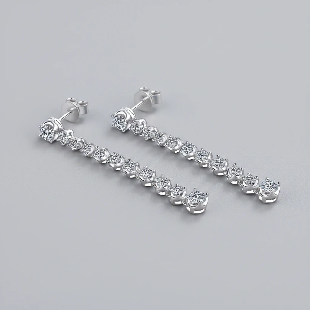 Pair of silver earrings with clear stones on a teal textured background