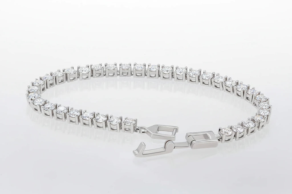 Silver bracelet with clear stones on a light blue floral background