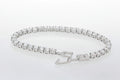 Silver bracelet with clear stones on a light blue floral background