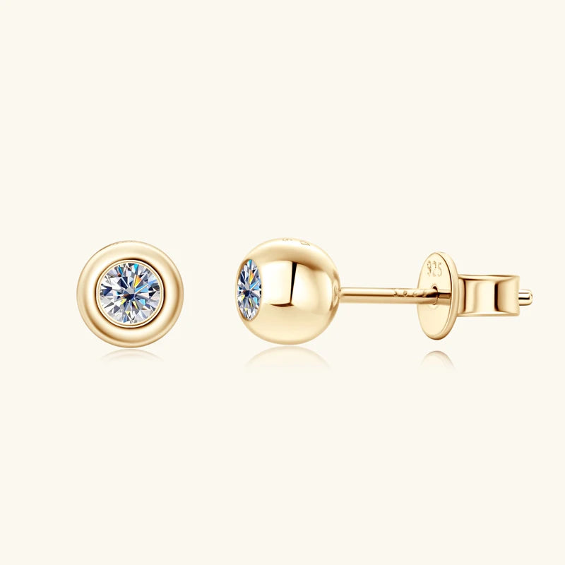 Gold earrings with clear gemstones on a white background