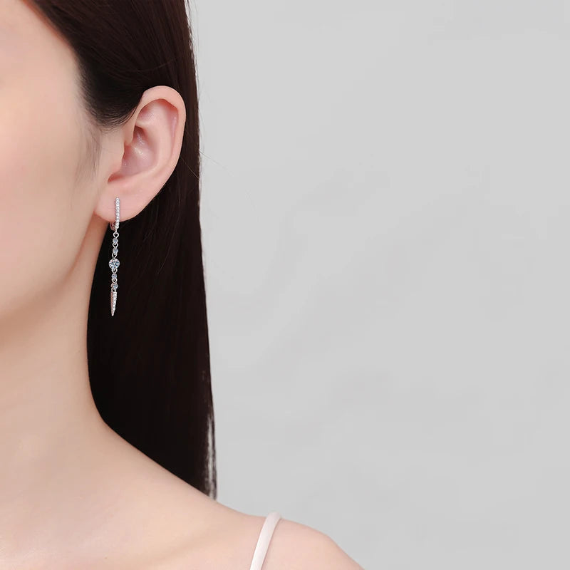 Earring worn by a person on a plain background