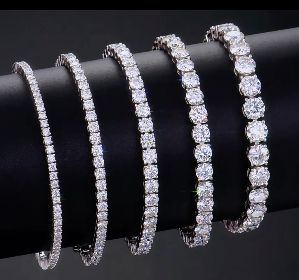 Four Moissanite bracelets on a black surface