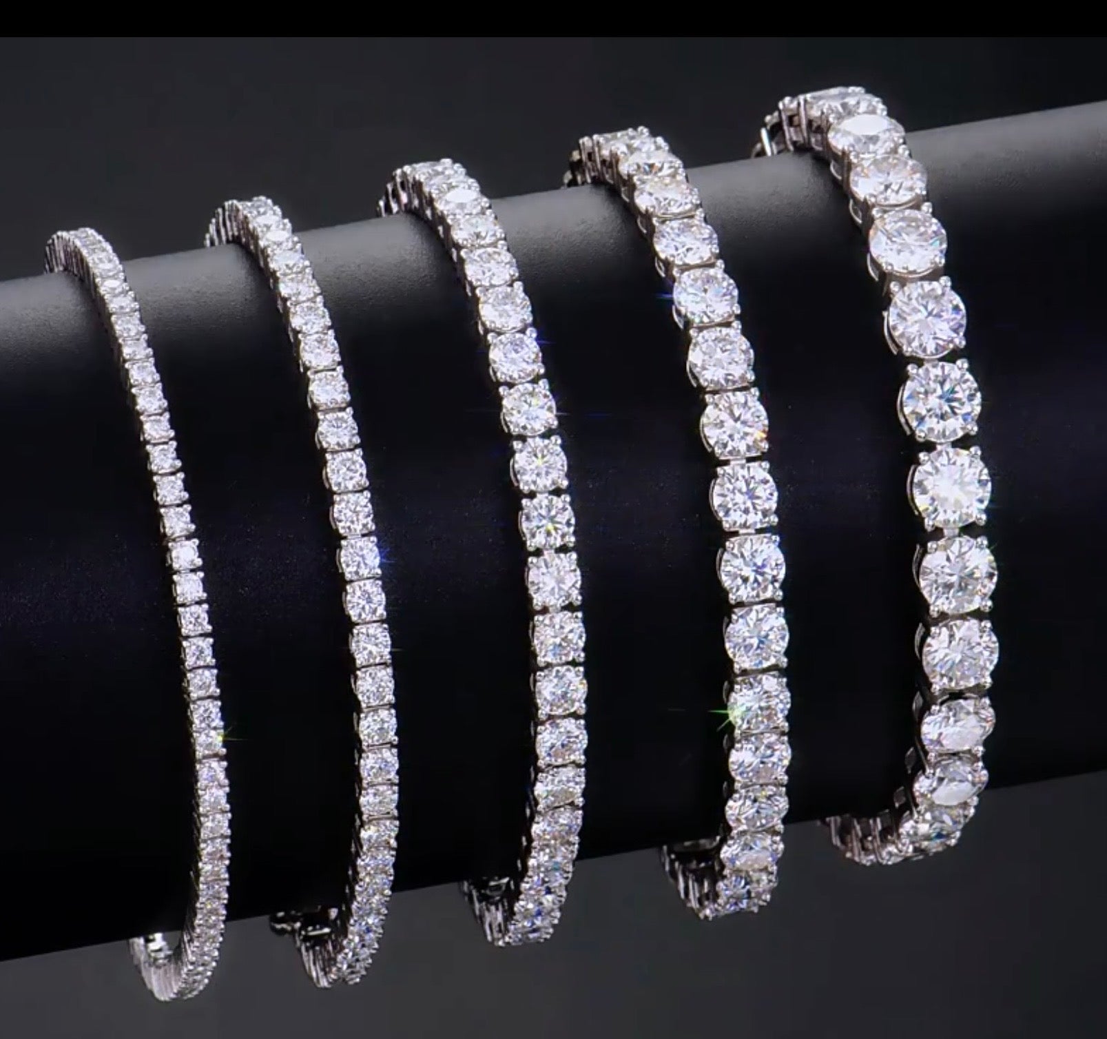 Four Moissanite bracelets on a black surface