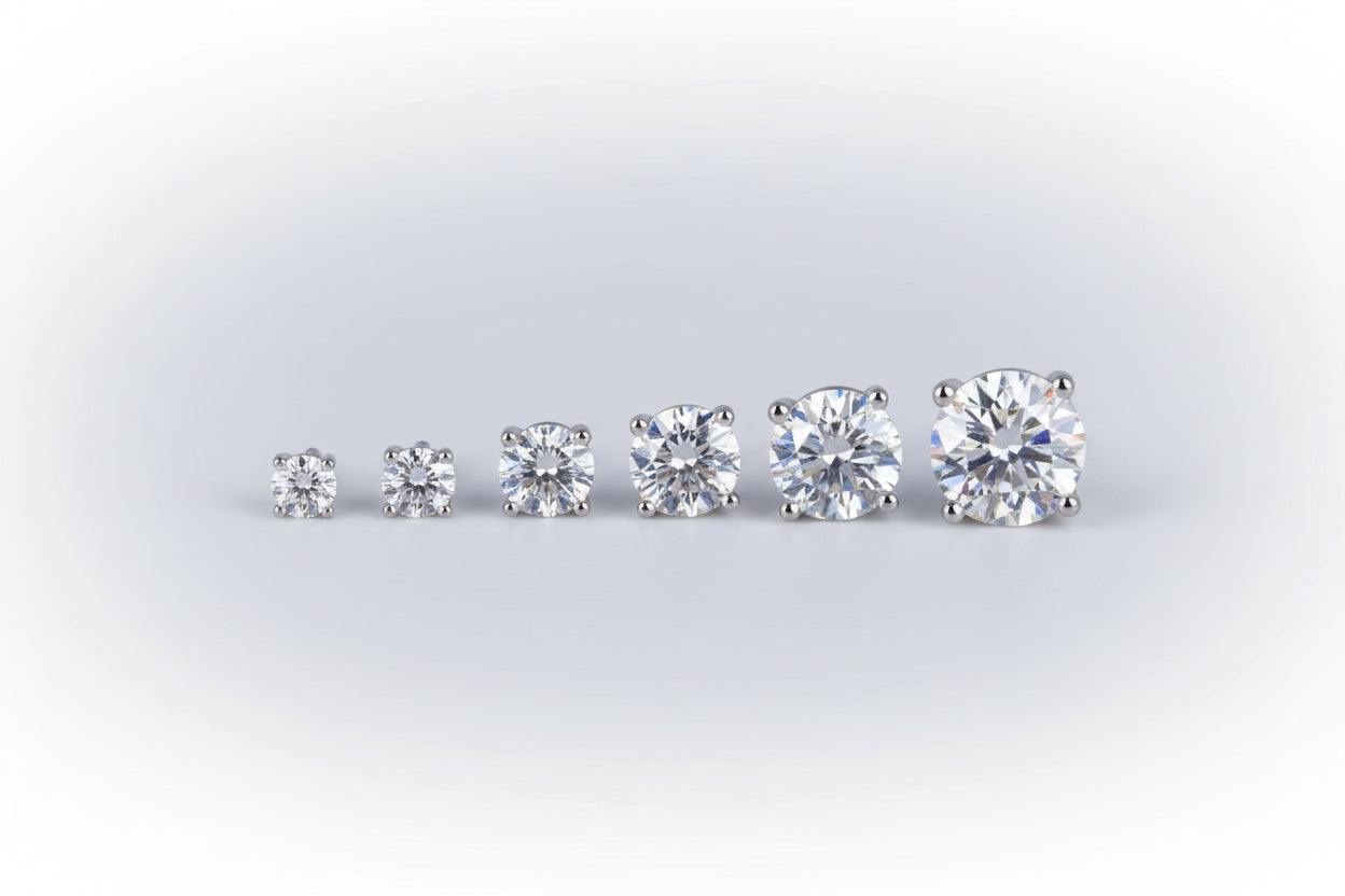 Pair of diamond stud earrings on a reflective black surface