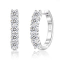 Silver hoop earrings with clear gemstones on a white background