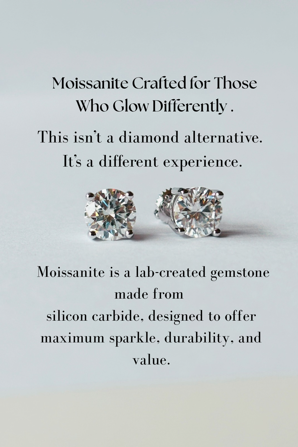 A pair of round brilliant-cut moissanite stud earrings displayed on a light gray background with descriptive text above and below. The text reads: 'Moissanite Crafted for Those Who Glow Differently.