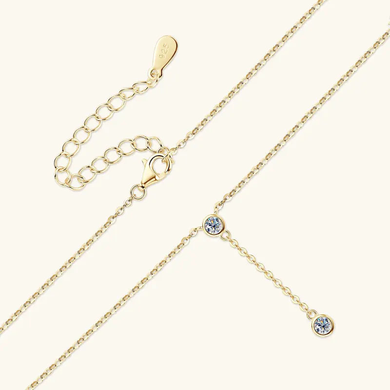 Gold necklace with small crystal pendants on a white background
