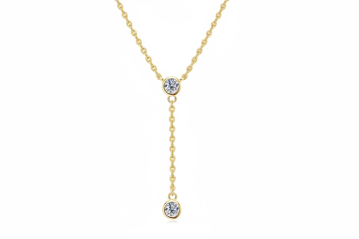 Gold necklace with two moissanite pendants on a white background, featuring the brand 